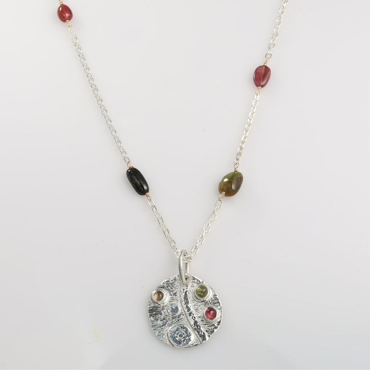 Necklace with a silver pendant and multicolored beads on a white background
