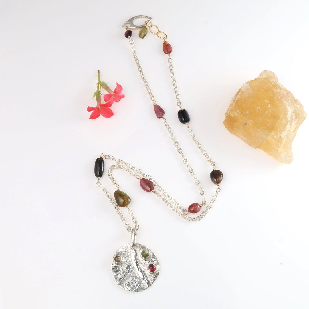 Necklace with gemstones and a pendant on a white background