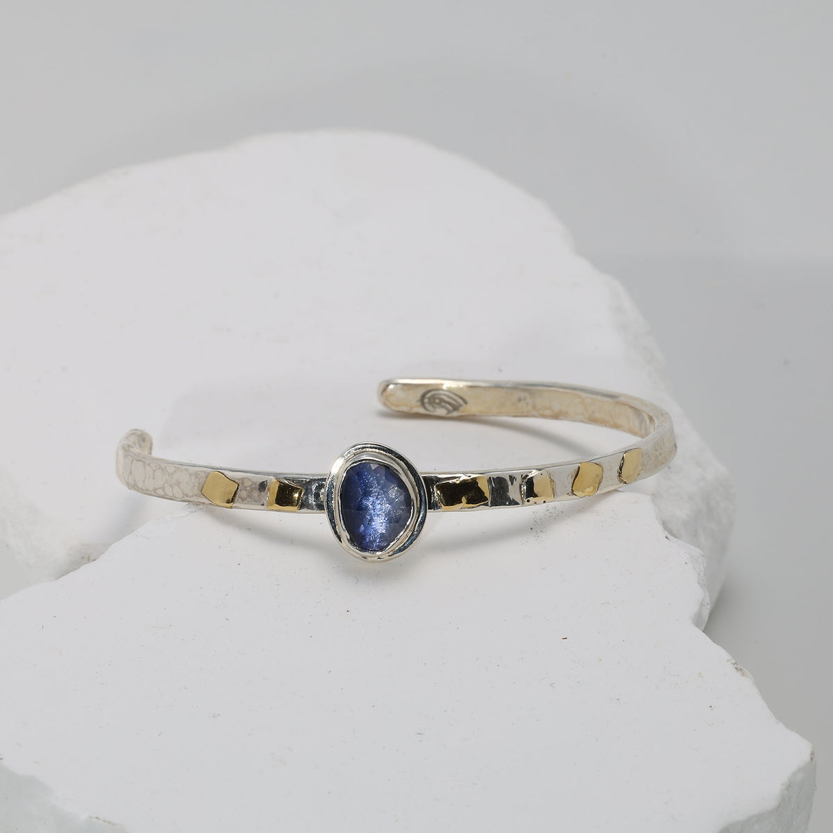 Deep blue sapphire bracelet in hammered Argentium silver with fused gold — classic and serene.
