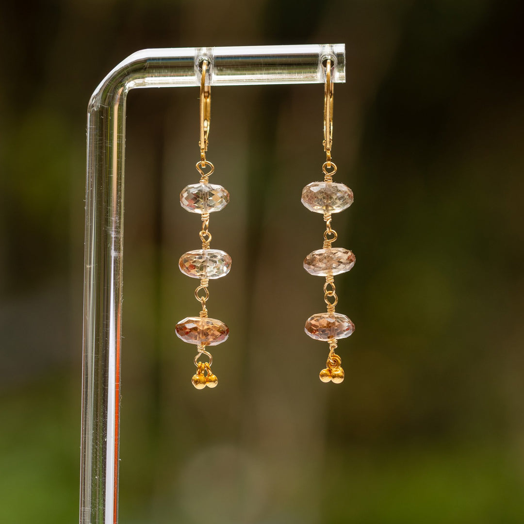 Stay Neutral champagne topaz gold drop earrings flat lay with orange flowers – Breathe Autumn Rain