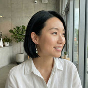 Life Style image of women wearing the smooth green tourmaline cabochon silver earrings.