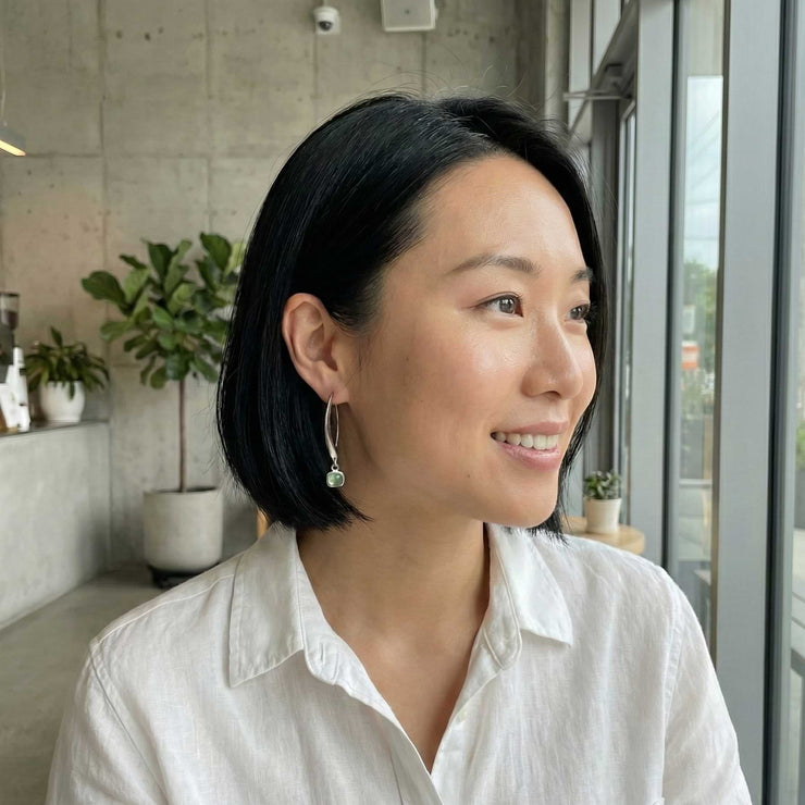 Life Style image of women wearing the smooth green tourmaline cabochon silver earrings.