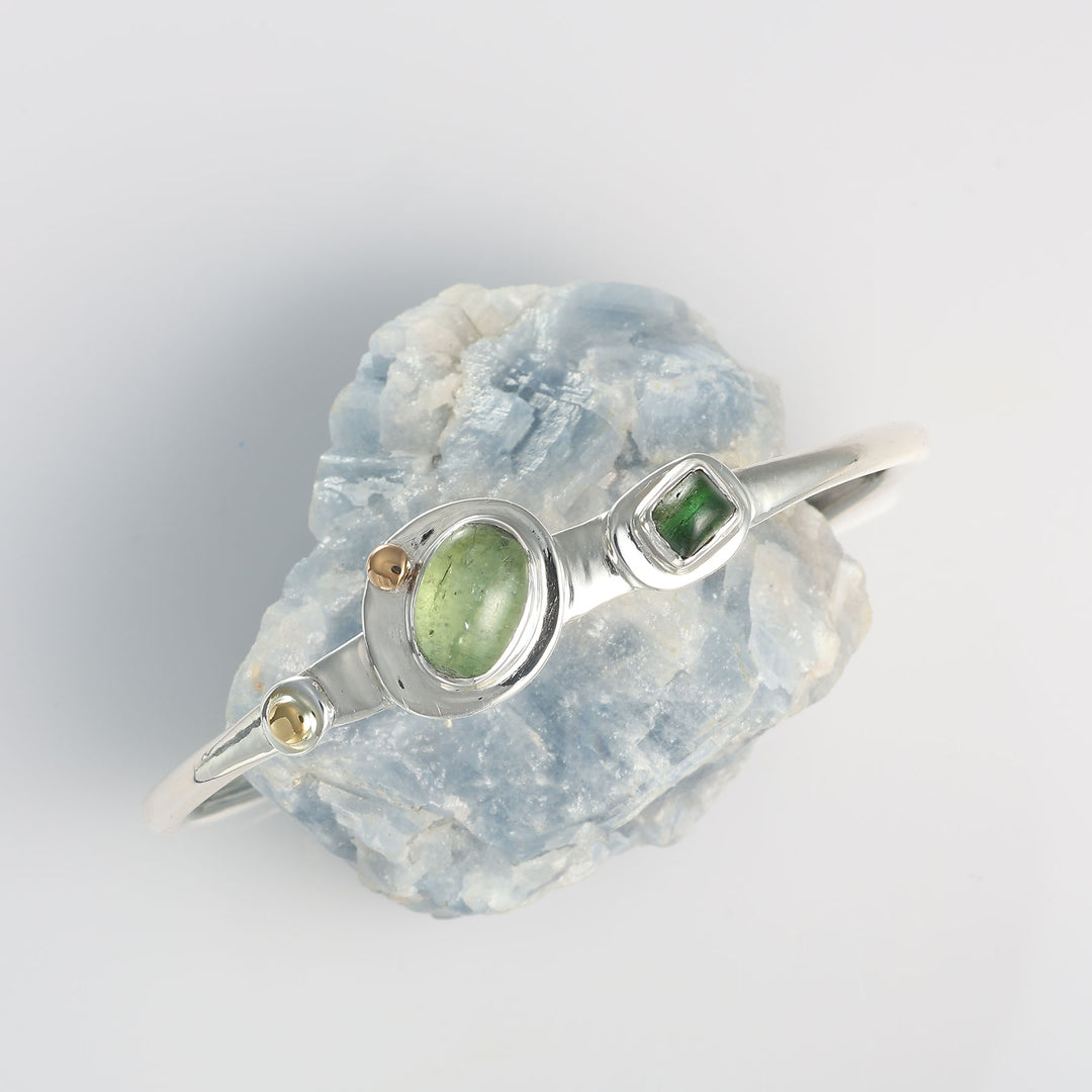 Handcrafted mixed metal cuff bracelet by Breathe Autumn Rain featuring an organic open-band design and natural green gemstones.