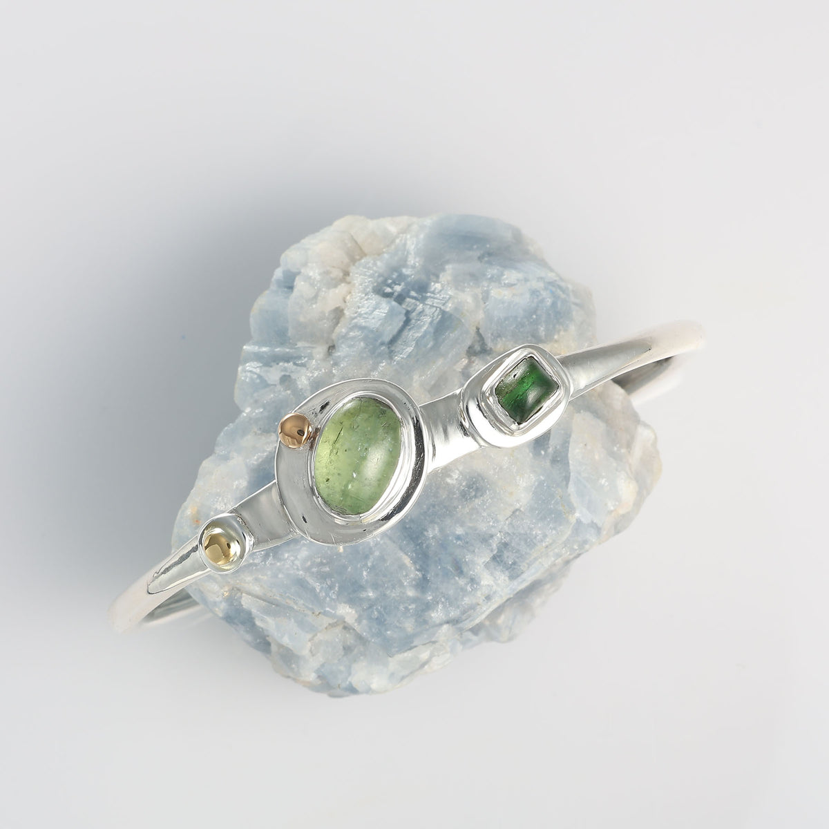 Handcrafted mixed metal cuff bracelet by Breathe Autumn Rain featuring an organic open-band design and natural green gemstones.