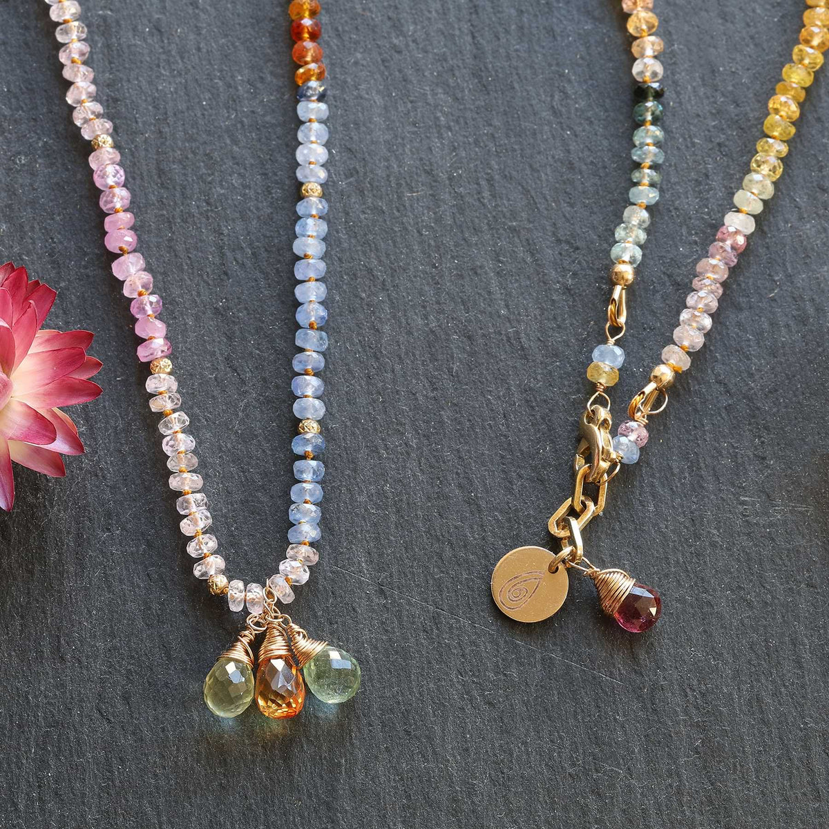 close-up of sapphire beads and gold accents on 14k gold necklace, styled with natural textures
