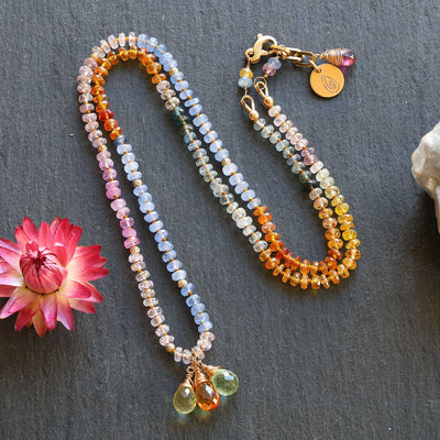 sapphire beads and gold accents on 14k gold necklace, styled with natural textures