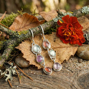 Long 3.5 inch silver statement earrings with colorful natural gemstones on a creative still life set.