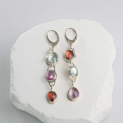 Three-tier linear drop earrings featuring rose-cut pink, orange, and green sapphires set in sterling silver.