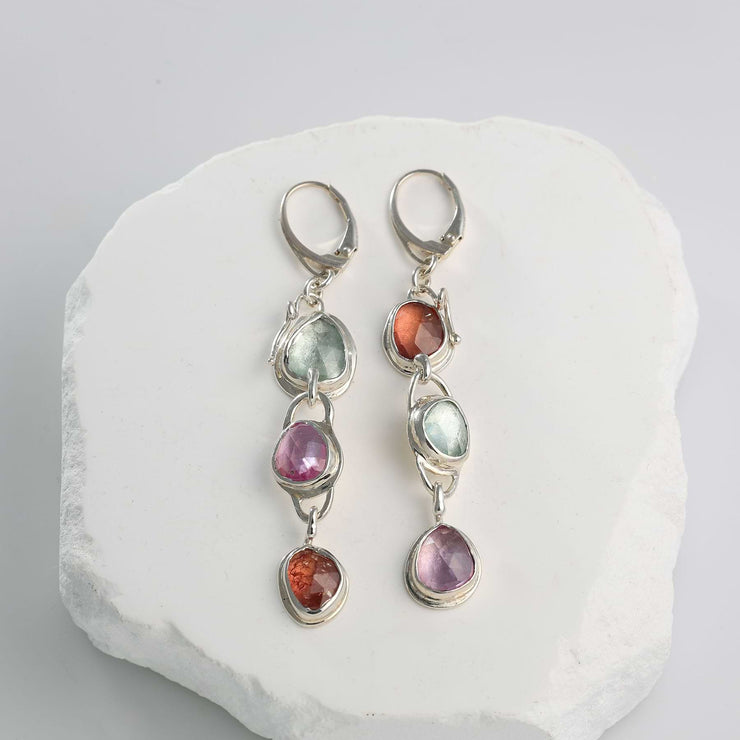 Three-tier linear drop earrings featuring rose-cut pink, orange, and green sapphires set in sterling silver.
