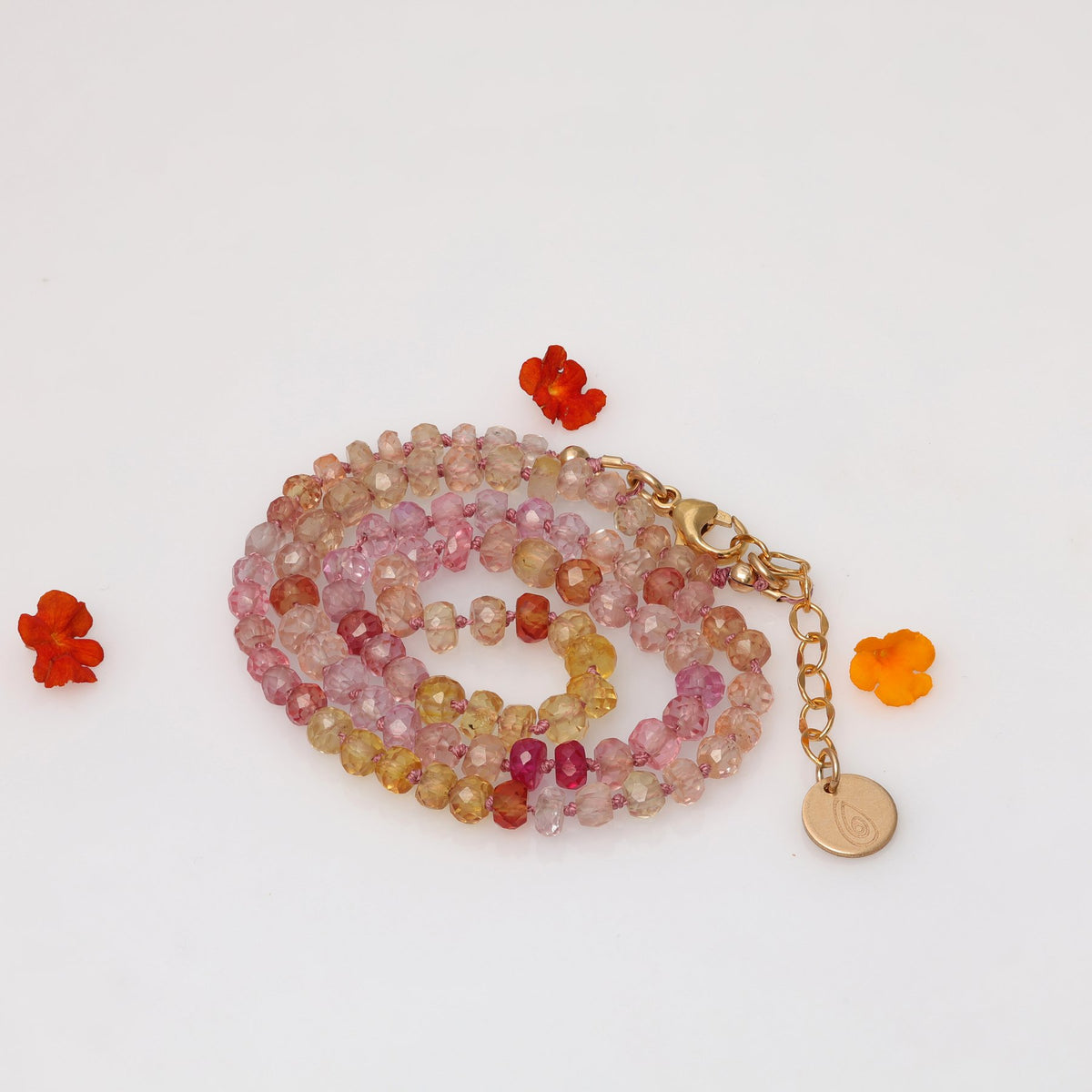 Peonies in Bloom padparadscha sapphire necklace coiled showing full gradient from blush to gold – Breathe Autumn Rain