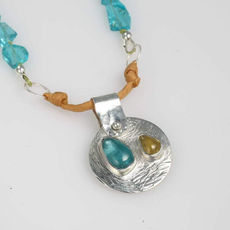 Beach Party necklace closeup with rare Paraiba blue and golden tourmalines set in Argentium silver, silk and sapphire strand — handcrafted by Breathe Autumn Rain.