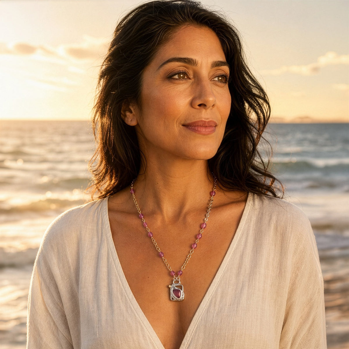 Woman wearing a necklace on a beach at sunset