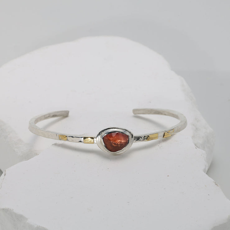 Fiery red sapphire cuff bracelet with warm gold fused onto textured Argentium silver.