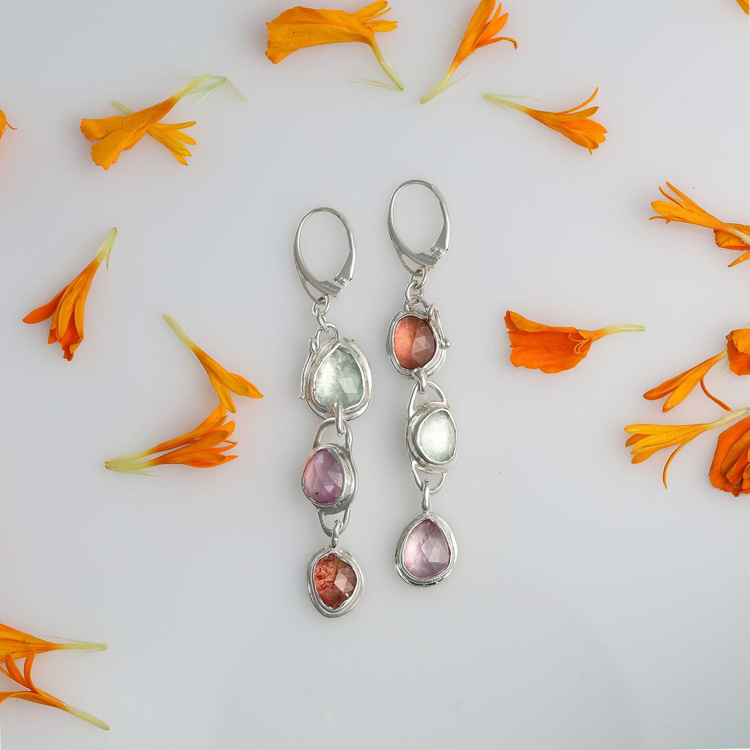 Long 3.5 inch silver statement earrings with colorful natural gemstones on a white shiny background.