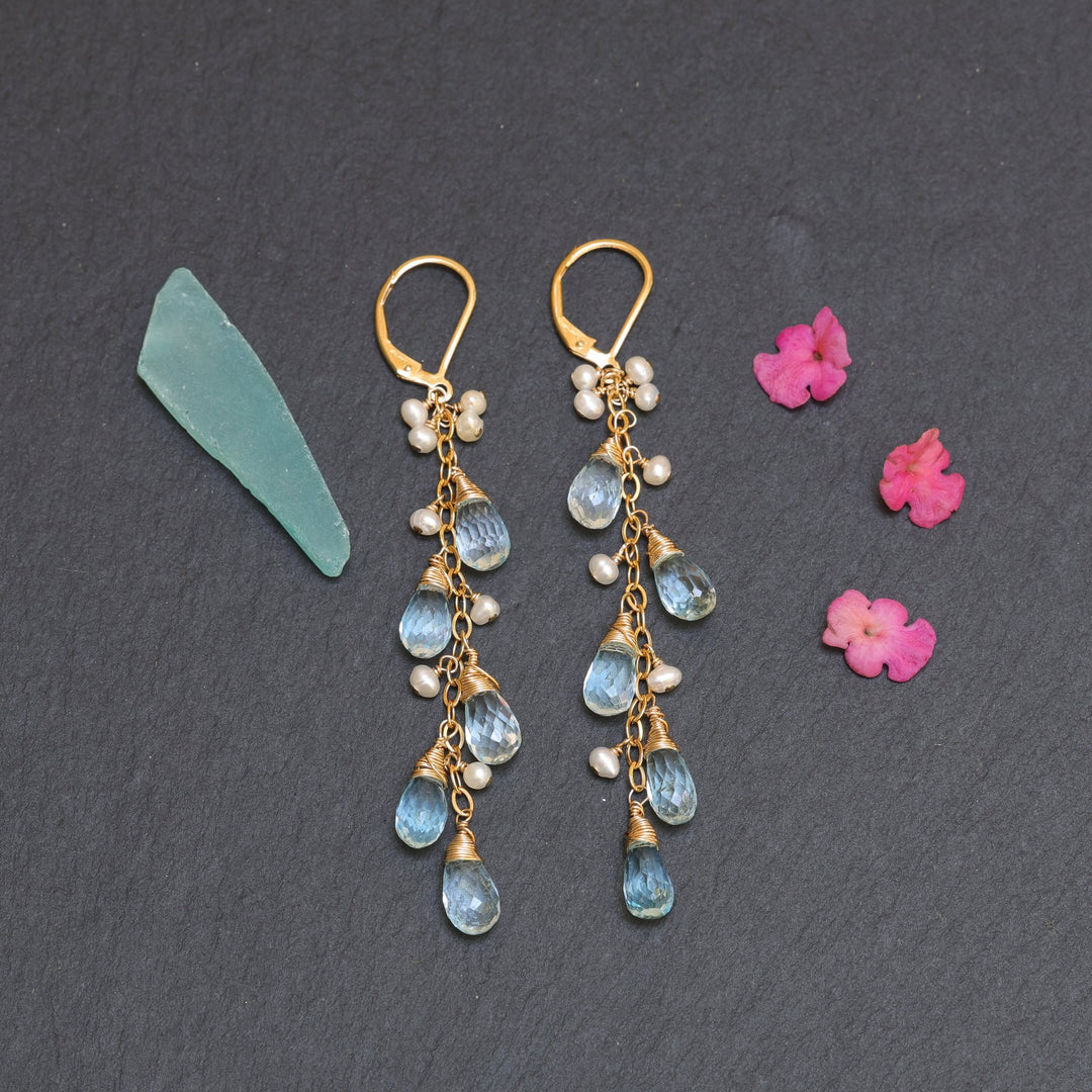 Cascading Rain Swiss blue topaz teardrop and pearl gold drop earrings on slate background – Breathe Autumn Rain
