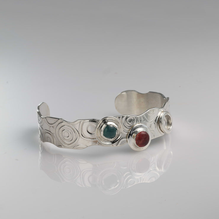 Textured Argentium silver cuff bracelet featuring retro swirl patterns and bezel-set multi-color tourmalines.